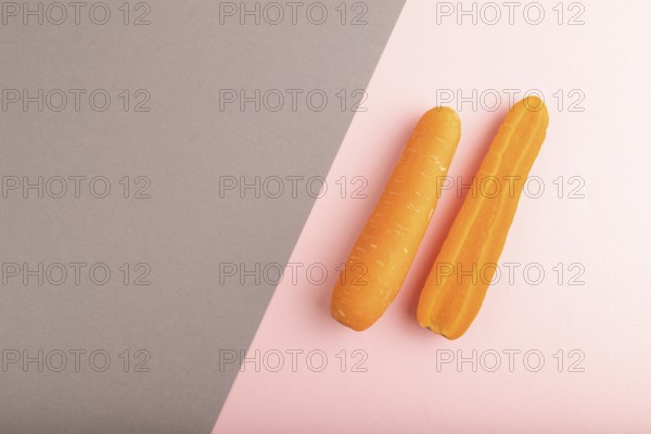 Orange Carrot on gray and pink pastel paper background. Top view, copy space, flat lay. healthy food, vegetable, minimalism