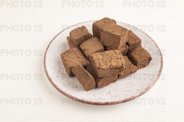 Chocolate marshmallow on white wooden background. side view, close up