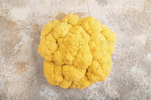 Yellow Cauliflower on brown concrete background. Top view, close up, flat lay. healthy food, vegetable, minimalism
