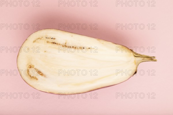 Purple Cutted eggplant with white stripes on pink pastel background. Top view, flat lay, copy space. Tropical, healthy food, vegetable, slice, minimalism