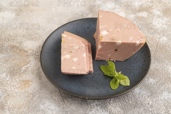 Mortadella sausage on wooden cutting board with pepper and herbs on brown concrete background. Side view, copy space