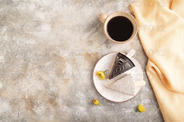 Chocolate and Vanilla Cake pops Marshmallow with cup of coffee on brown concrete background and orange linen textile. top view, flat lay, copy space