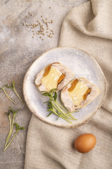 Chicken, egg and dried apricot meatloaf, microgreen on brown concrete background and linen textile. top view, flat lay, close up