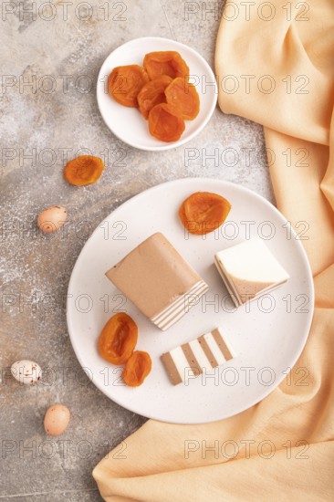 Cocoa and milk jelly with dried apricots on brown concrete background and orange textile, top view, flat lay, close up, minimalism