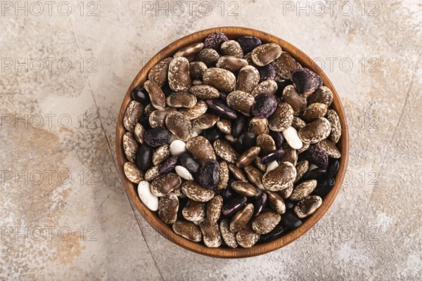 Wooden bowl with Kidney beans on brown concrete background, top view, flat lay, copy space, minimalism