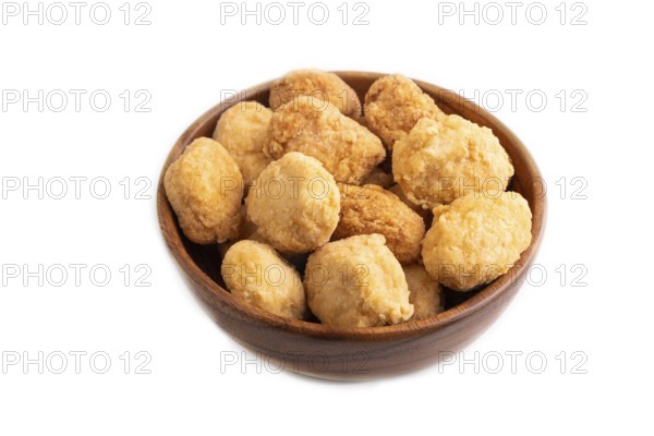 Fried crispy Chicken Nuggets in brown wooden bowl isolated on white background. side view, copy space