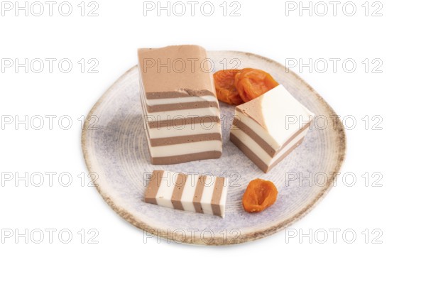 Cocoa and milk jelly with dried apricots isolated on white background, side view, minimalism