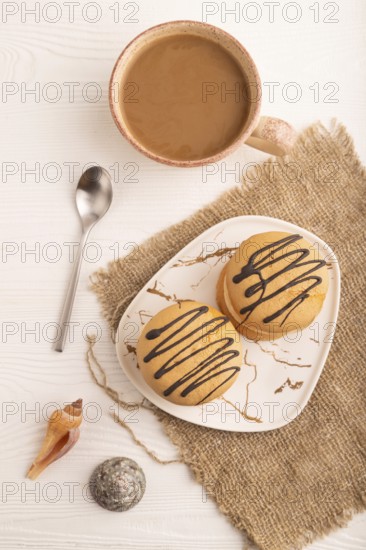 Caramel Cream Cakes on white wooden background and linen textile, cup of coffee, top view, flat lay, close up