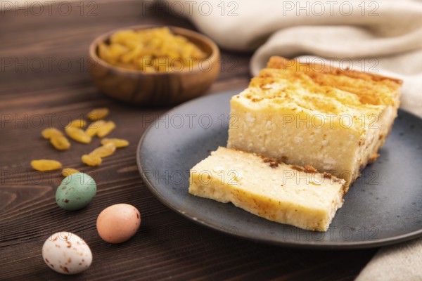 ?ottage cheese ?asserole, Curd cake, with dried apricots and raisins on brown wooden background and linen textile, side view, close up, minimalism, selective focus