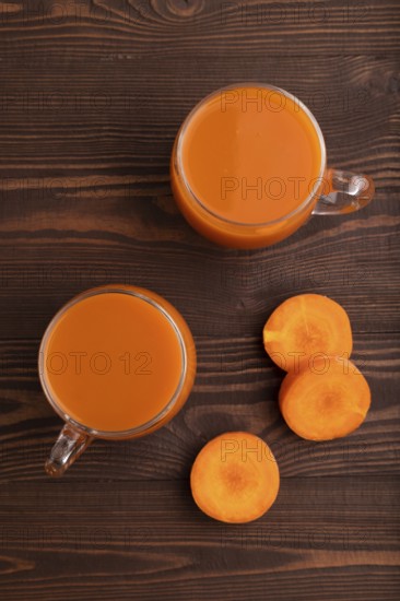 Two glasses with carrot juice, on wooden background. Diet, healthy eating concept. top view, flat lay, close up, minimalism