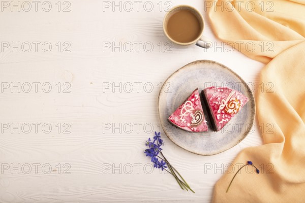 Chocolate cake on white wooden background and orange linen textile, cup of coffee, top view, flat lay, copy space
