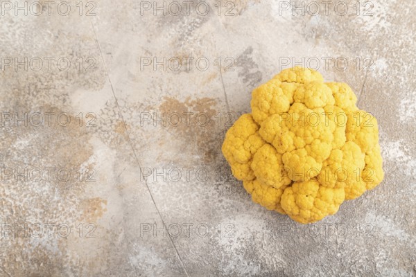 Yellow Cauliflower on brown concrete background. Top view, copy space, flat lay. healthy food, vegetable, minimalism