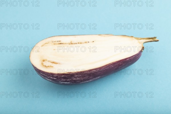 Purple Cutted eggplant with white stripes on blue pastel background. Side view, copy space. Tropical, healthy food, vegetable, slice, minimalism