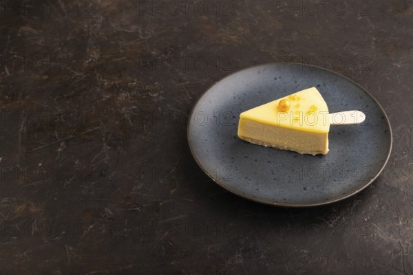 Yellow Cake pop with sprinkles on blue ceramic plate on black concrete background, side view, copy space, minimalism