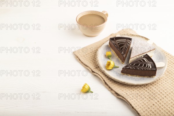 Chocolate and Vanilla Cake pops Marshmallow with cup of coffee on white wooden background and beige linen textile. side view, copy space