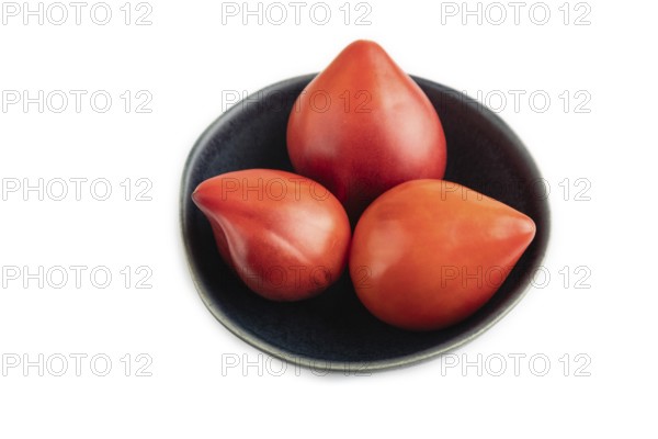 Red Heart shape tomatoes in blue bowl isolated on white background. Side view, copy space, flat lay. healthy food, vegetable, minimalism