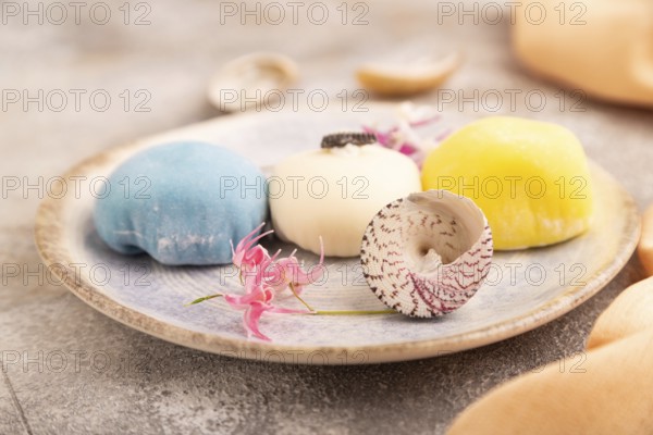 Japanese Mochi Cakes on brown concrete background and orange textile, side view, close up, selective focus