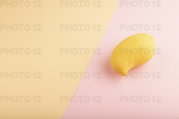 Orange mango on orange and pink paper pastel background. Side view, copy space. healthy food, minimalism