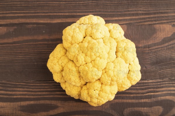 Yellow Cauliflower on brown wooden background. Top view, close up, flat lay. healthy food, vegetable, minimalism