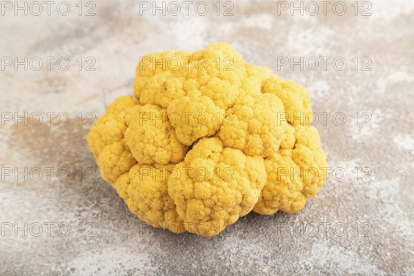 Yellow Cauliflower on brown concrete background. Side view, close up. healthy food, vegetable, minimalism