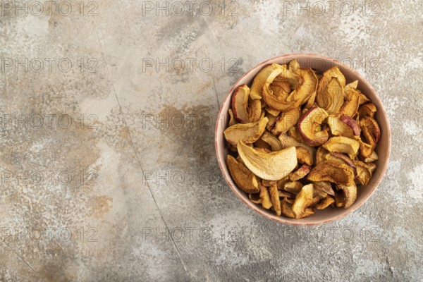 Dried Apples in ceramic bowl on brown concrete background. Top view, copy space, flat lay. healthy food, minimalism. sweet