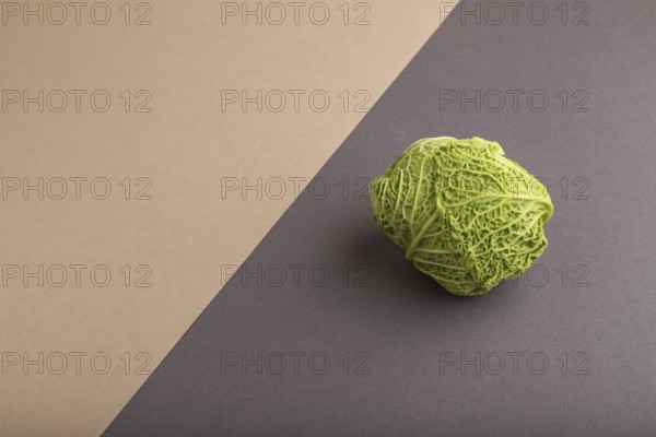 Green lettuce on beige and gray pastel paper background. Side view, copy space, flat lay. healthy food, vegetable, minimalism