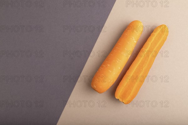 Orange Carrot on beige and gray pastel paper background. Top view, copy space, flat lay. healthy food, vegetable, minimalism