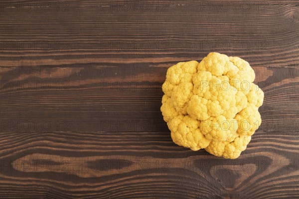 Yellow Cauliflower on brown wooden background. Top view, copy space, flat lay. healthy food, vegetable, minimalism