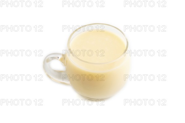 Organic non dairy banana and soy milk in glass isolated on white background. Vegan healthy food concept, flat lay, side view, close up