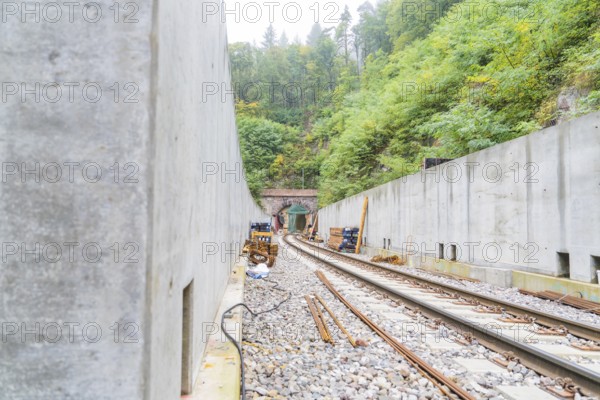 Blick auf Eisenbahngleise, die zu einem Tunnel führen, flankiert von massiven Betonwänden, Bau der Hermann Hessenahn, Calw, Schwarzwald, Deutschland