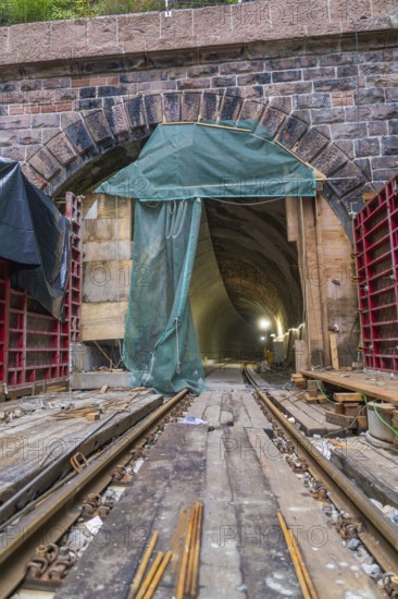 Ansicht eines Tunnels mit sichtbaren Schienen und Baugerüst, beleuchtet durch Baustellenlampen, Bau der Hermann Hessenahn, Calw, Schwarzwald, Deutschland