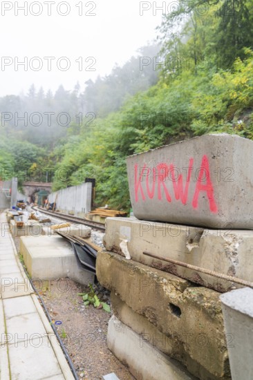 Baustelle mit Betonblöcken, auf einem steht rotes Graffiti 'Kurwa', Bau der Hermann Hessenahn, Calw, Schwarzwald, Deutschland