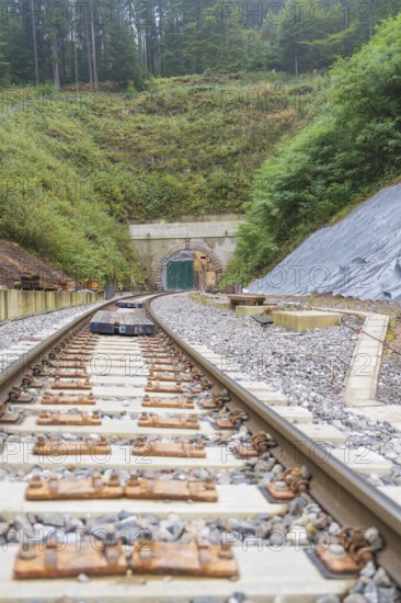 Gleise, die zu einem Tunnel führen, umgeben von Wald und Baustelle, Bau der Hermann Hessenahn, Calw, Schwarzwald, Deutschland