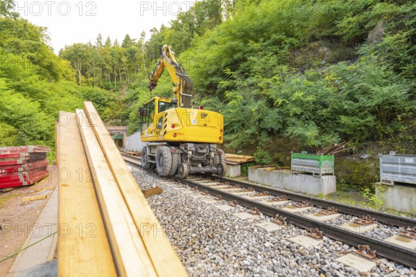 Baufahrzeug mit Kran auf Schienen in einer bewaldeten Baustelle, Bau der Hermann Hessenahn, Calw, Schwarzwald, Deutschland