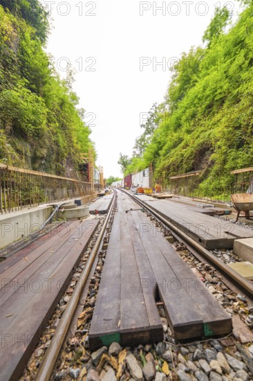 Eisenbahnschienen mit Holzplanken in einer eingefassten, grünen Bauumgebung, Bau der Hermann Hessenahn, Calw, Schwarzwald, Deutschland