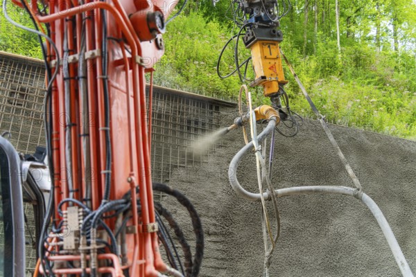 Detailaufnahme einer Maschine beim Auftragen von Spritzbeton vor grüner Kulisse, Bau der Hermann Hessenahn, Calw, Schwarzwald, Deutschland