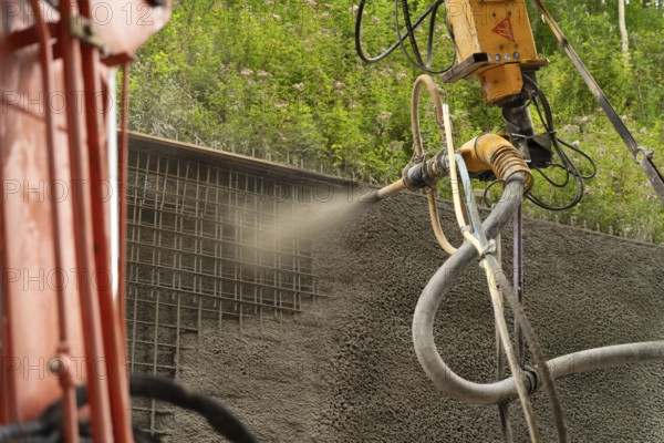 Spritzbeton wird maschinell auf ein Gitter an einem Hang aufgetragen, Bau der Hermann Hessenahn, Calw, Schwarzwald, Deutschland