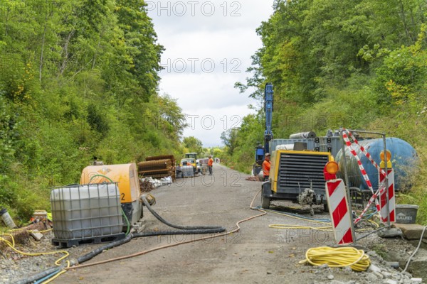 Baustellenszene mit Maschinen und Geräten entlang einer Straße in bewaldetem Gebiet, Bau der Hermann Hessenahn, Calw, Schwarzwald, Deutschland