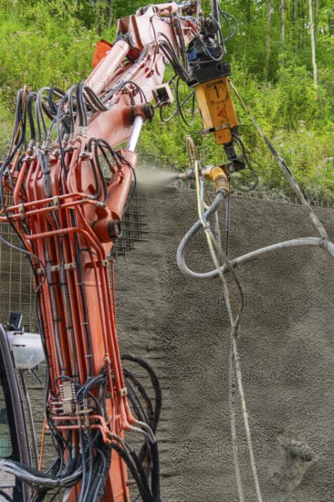 Industrielles Baugerät sprüht Beton auf strukturierten Untergrund umgeben von Vegetation, Bau der Hermann Hessenahn, Calw, Schwarzwald, Deutschland