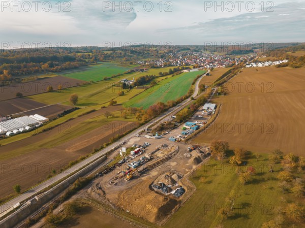 Luftaufnahme einer ländlichen Landschaft mit Baustelle, umgeben von Feldern und kleinen Dörfern im Herbst, Neubautunnel der Hermann Hessebahn, Calw, Schwarzwald, Deutschland