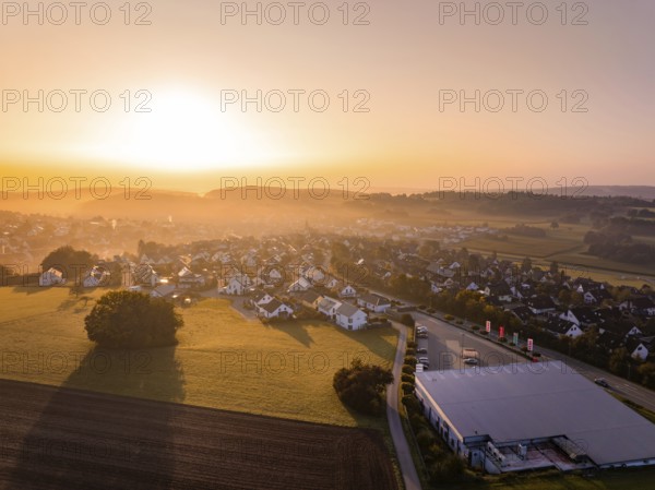 Blick auf ein schlafendes Dorf im Licht eines sanften Sonnenaufgangs, Gechingen, Heckengäu, Landkreis Calw, Deutschland