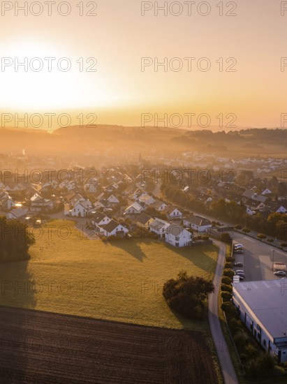 Dorfansicht bei Sonnenaufgang mit beleuchteten Dächern und umliegenden Feldern, Gechingen, Heckengäu, Landkreis Calw, Deutschland