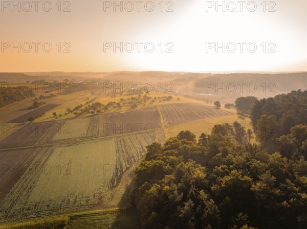 Morgenstimmung mit Nebel und Sonnenaufgang über einer ländlichen Landschaft, Gechingen, Heckengäu, Landkreis Calw, Deutschland