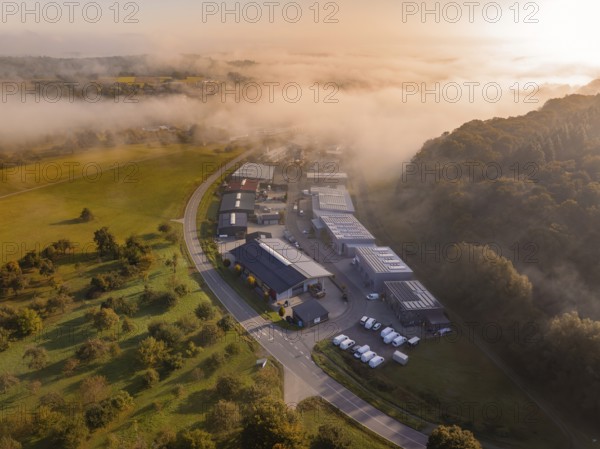 Luftaufnahme eines Industriegebiets bei nebligem Morgenlicht mit umliegenden Feldern, Gechingen, Heckengäu, Landkreis Calw, Deutschland