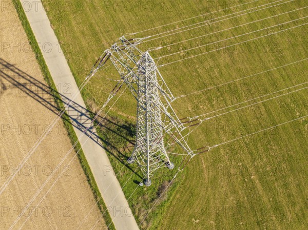 Hochspannungsmast auf einer Wiese, mit langen Schatten, eingefangen aus der Vogelperspektive, Nagold, Schwarzwald, Deutschland
