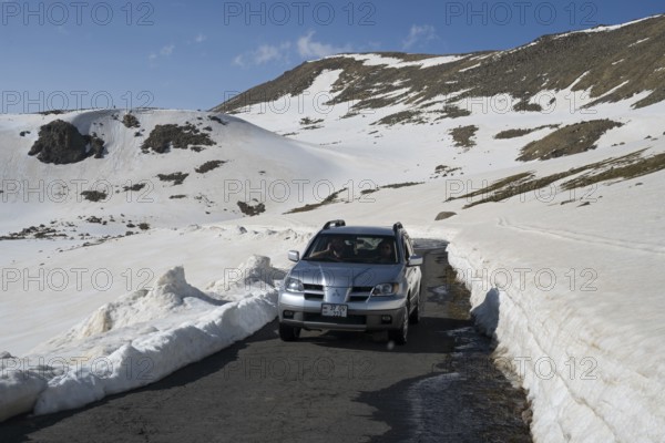 SUV auf enger, von Schnee gesäumter Bergstraße mit klarem Himmel, Aragaz, Aragats, Aragac, Alagyaz, erloschener Schichtvulkan, 4090 m, Aragazotn, Schirak, Armenien