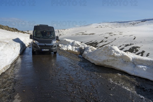Van auf schmelzender Straße zwischen hohen Schneewänden in bergiger Umgebung, mit dem Camper zum Aragaz, Aragats, Aragac, Alagyaz, erloschener Schichtvulkan, 4090 m, Aragazotn, Schirak, Armenien