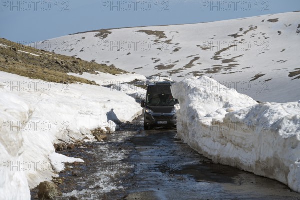 Van fährt auf schneebedeckter Bergstraße unter klarem Himmel, mit dem Camper zum Aragaz, Aragats, Aragac, Alagyaz, erloschener Schichtvulkan, 4090 m, Aragazotn, Schirak, Armenien