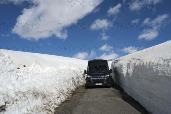 Van zwischen hohen Schneewehen auf einer Bergstraße unter klarem Himmel, mit dem Camper zum Aragaz, Aragats, Aragac, Alagyaz, erloschener Schichtvulkan, 4090 m, Aragazotn, Schirak, Armenien