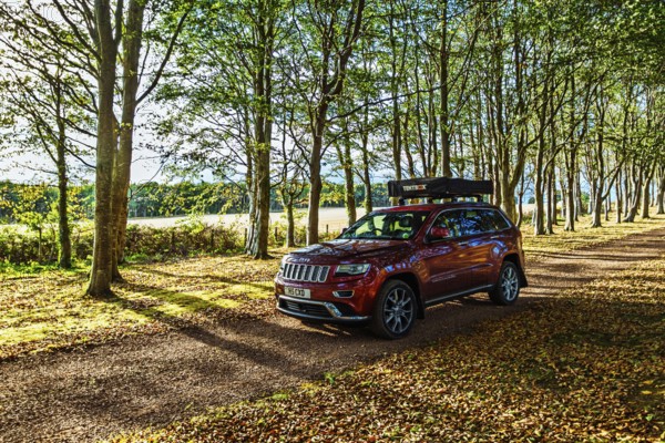 4x4 car with roof tent on autumn forest road, Tyninghame House, River Tyne, East Lothian, Scotland, UK
